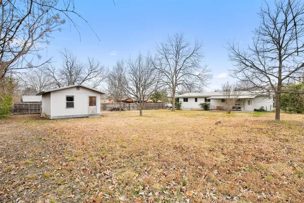 a view of house with yard and trees