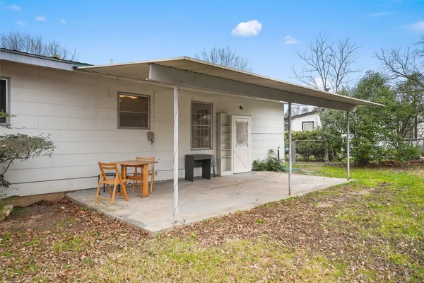 a backyard of a house with table and chairs
