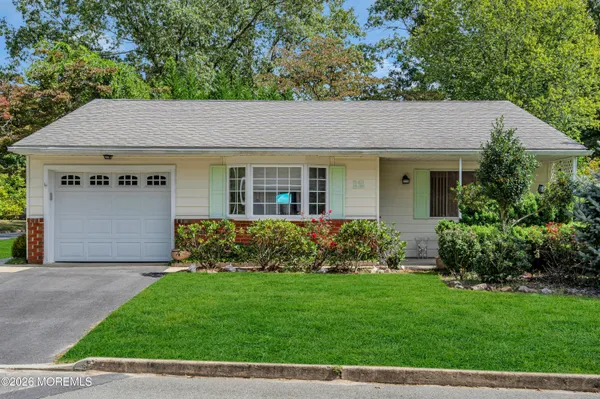 a front view of a house with a garden and yard