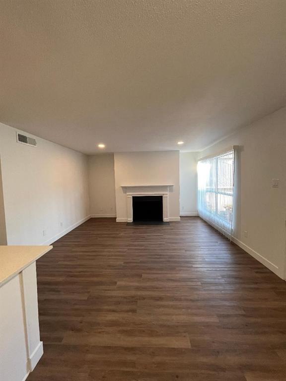 4020 Rawlins Street, Unit 102 Dallas, TX 75219 - Photo 2 of 11 a view of empty room with wooden floor and fireplace
