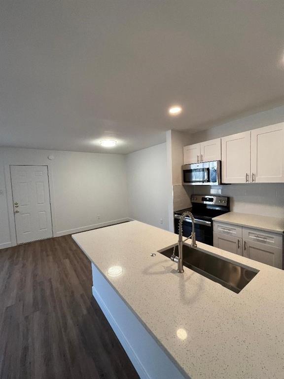 4020 Rawlins Street, Unit 102 Dallas, TX 75219 - Photo 4 of 11 a kitchen with kitchen island sink and stove