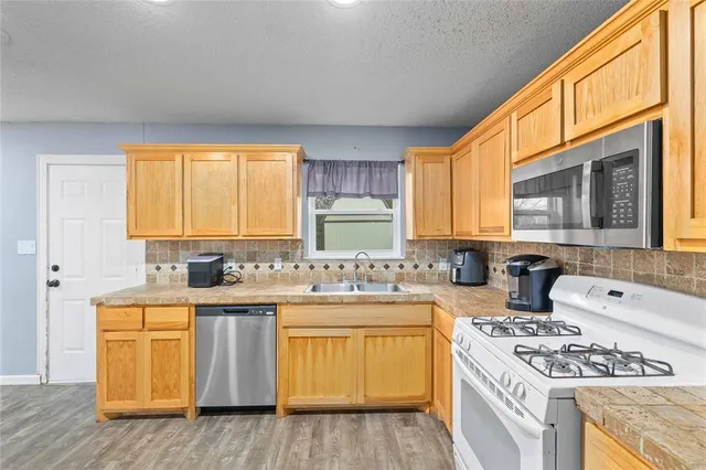 a kitchen with a sink stove and cabinets
