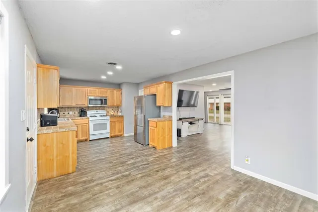 a kitchen with a refrigerator and a stove top oven