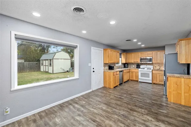 a kitchen with a refrigerator and a stove top oven
