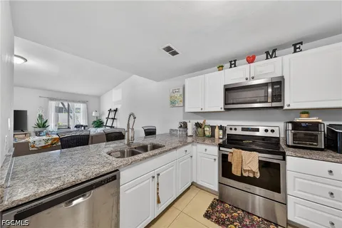 a kitchen with stainless steel appliances granite countertop a stove a sink and a microwave