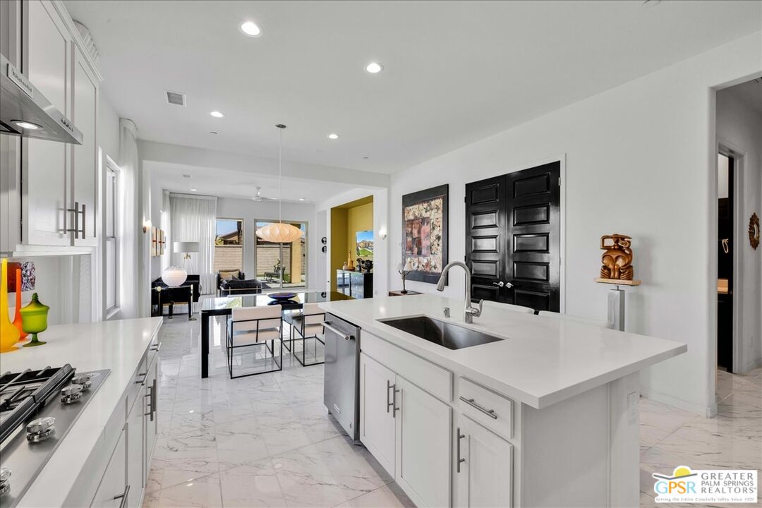 64 Claret Road Rancho Mirage, CA 92270 - Photo 16 of 30 a kitchen that has a lot of cabinets a sink and a stove in it