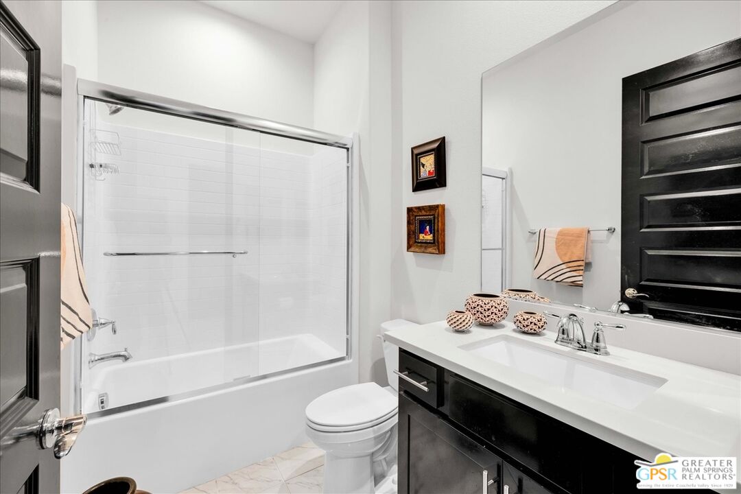 64 Claret Road Rancho Mirage, CA 92270 - Photo 24 of 30 a bathroom with a sink a toilet a mirror and shower