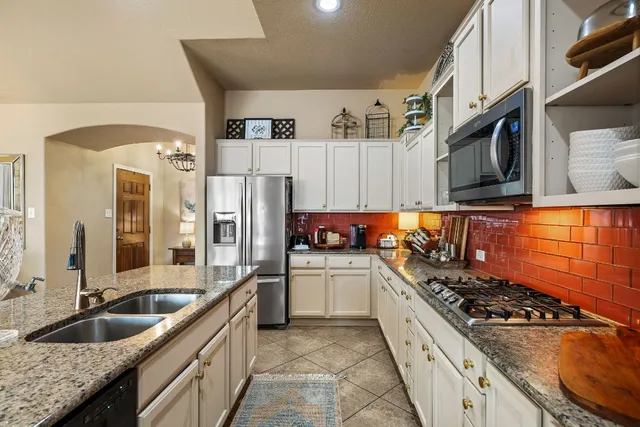 a kitchen with stainless steel appliances granite countertop a sink stove oven and refrigerator