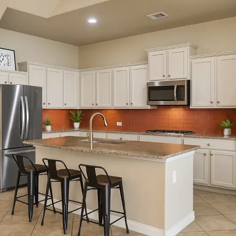 a kitchen with stainless steel appliances granite countertop a stove a sink a microwave and a refrigerator