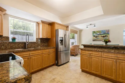 a kitchen with stainless steel appliances granite countertop a refrigerator sink and stove