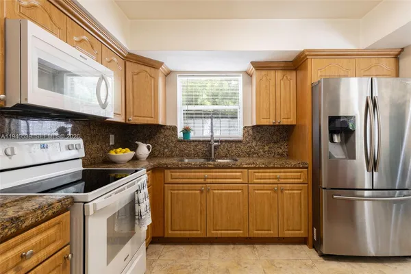 a kitchen with a refrigerator sink and cabinets