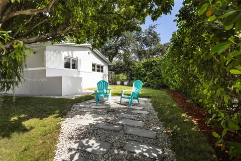 a view of a chair and table in backyard of the house
