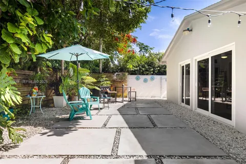 a view of a patio with table and chairs under an umbrella