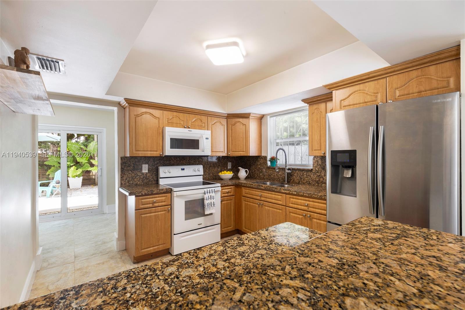 2201 Southwest 22nd Terrace Miami, FL 33145 - Photo 10 of 25 a kitchen with granite countertop a refrigerator stove top oven and sink