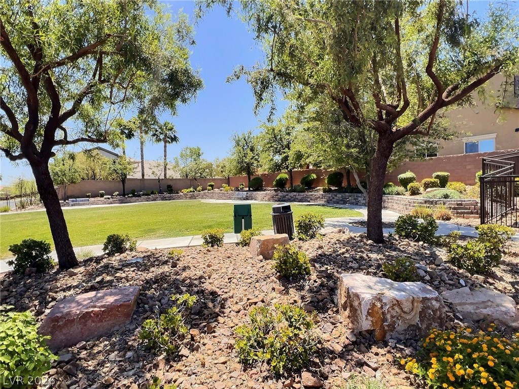 9724 University Ridge Avenue Las Vegas, NV 89149 - Photo 40 of 61 A vibrant green lawn and well-maintained shrubbery create a welcoming community space.