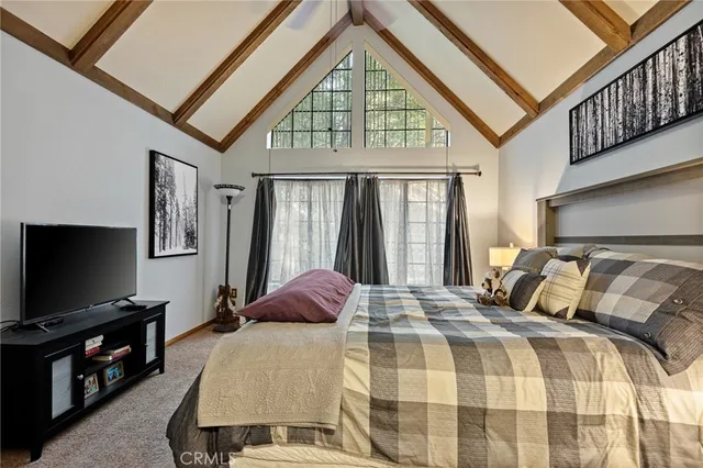 a bedroom with a bed and a lamp on dresser