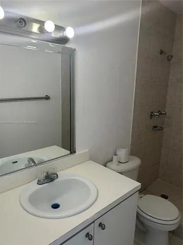 a bathroom with a sink and mirror with toilet