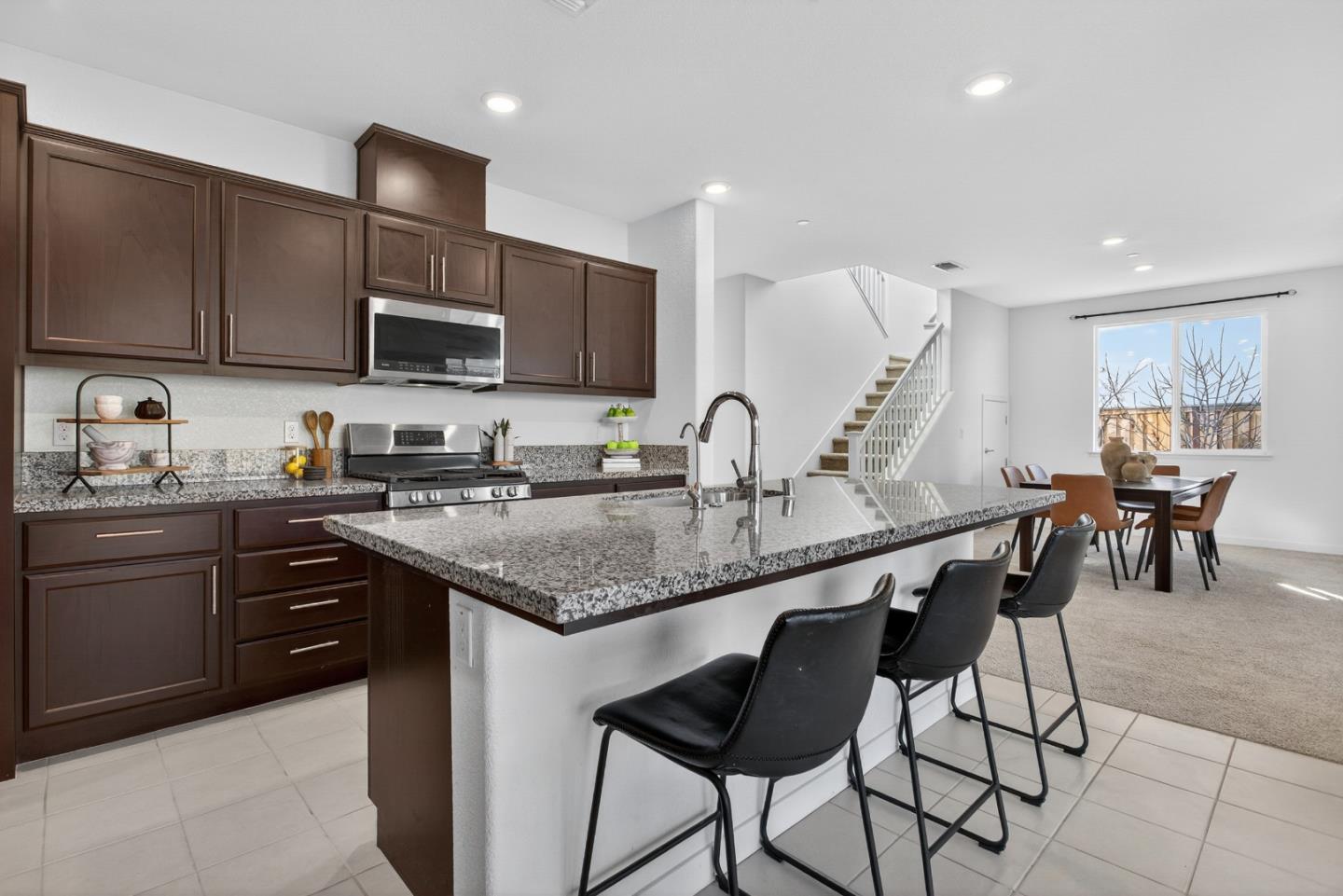 17533 Pegasus Court Lathrop, CA 95330 - Photo 23 of 59 a kitchen with stainless steel appliances granite countertop a stove top oven a sink a dining table and chairs