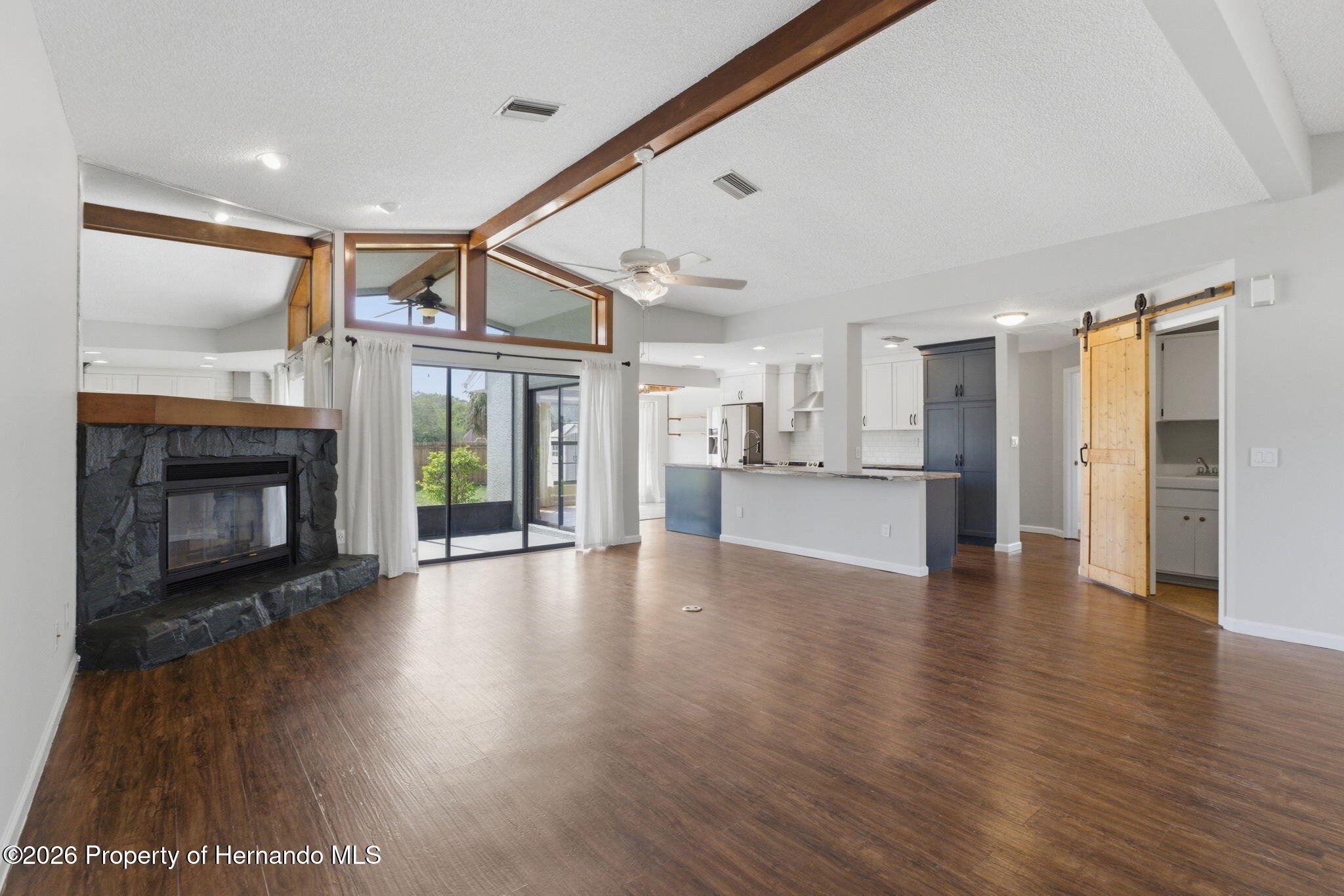 4966 Keysville Avenue Spring Hill, FL 34608 - Photo 12 of 50 a view of an empty room with wooden floor fireplace and a window