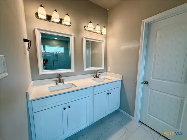 a bathroom with a double vanity sink and a mirror