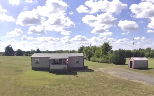a view of a big yard with an empty tree