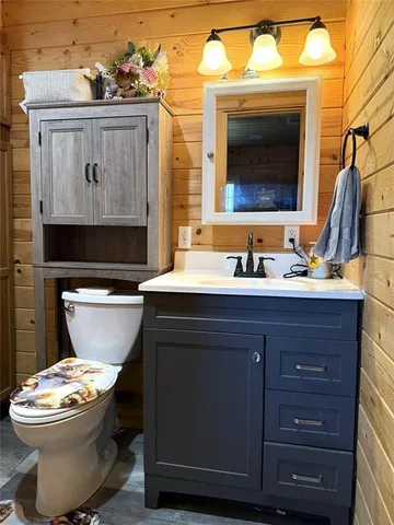 a bathroom with a sink a toilet a mirror and shower