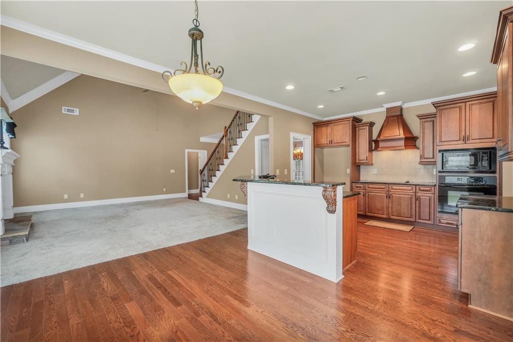 108 Caraway Road Locust Grove, GA 30248 - Photo 13 of 50 a view of a kitchen with kitchen island a counter top space stainless steel appliances and a ceiling fan