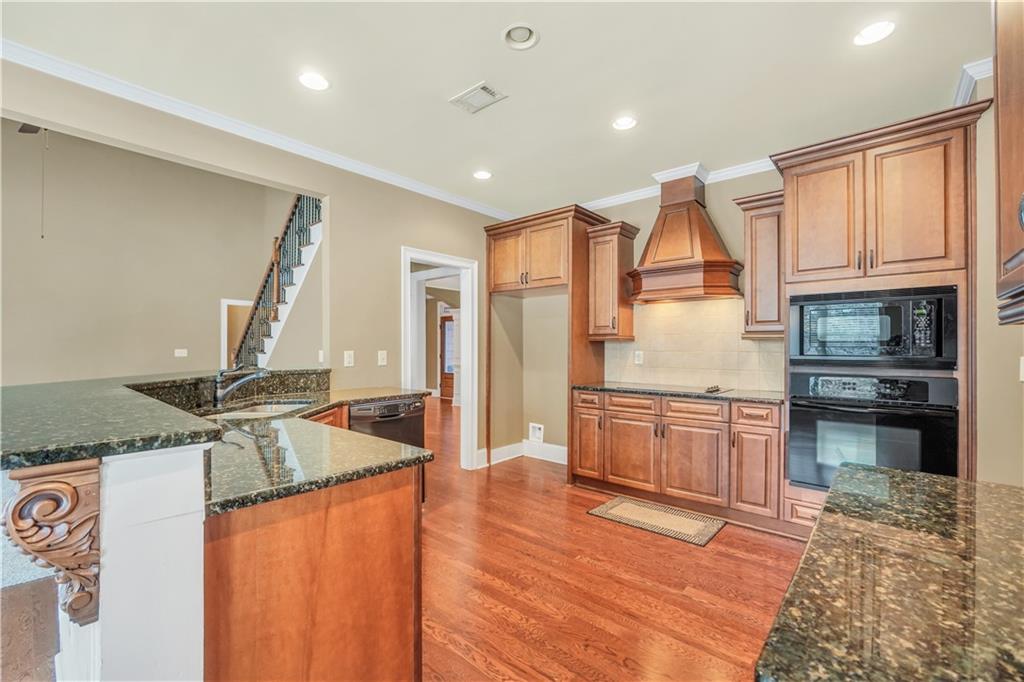 108 Caraway Road Locust Grove, GA 30248 - Photo 15 of 50 a kitchen with stainless steel appliances granite countertop a refrigerator a stove and a sink with wooden floors