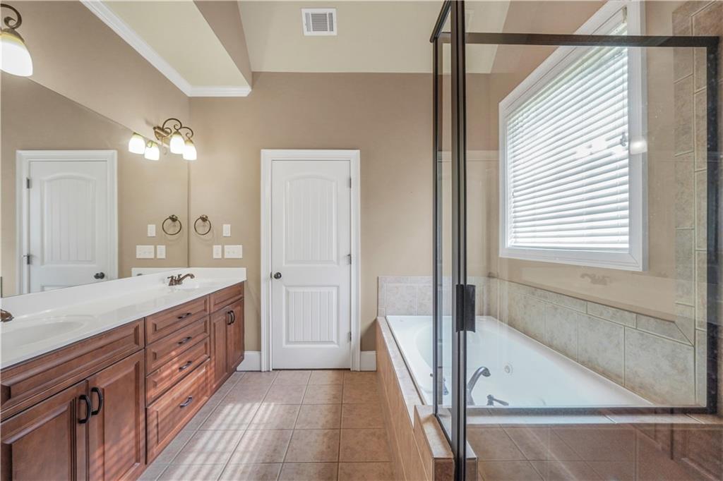108 Caraway Road Locust Grove, GA 30248 - Photo 28 of 50 a spacious bathroom with a double vanity sink a mirror and a shower