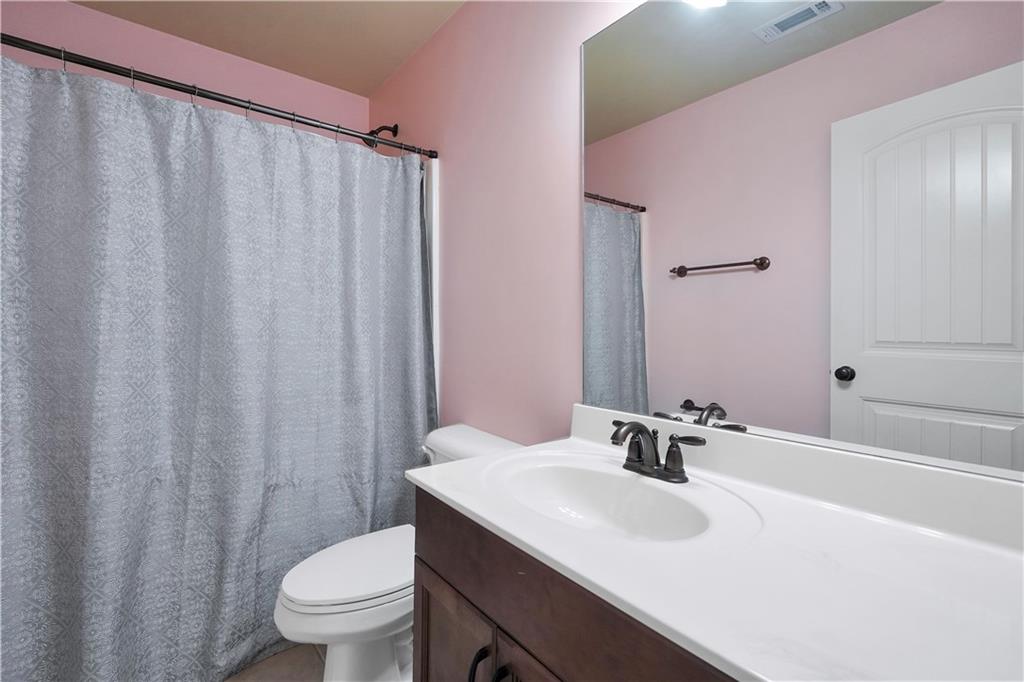 108 Caraway Road Locust Grove, GA 30248 - Photo 35 of 50 a bathroom with a sink a toilet and shower curtain