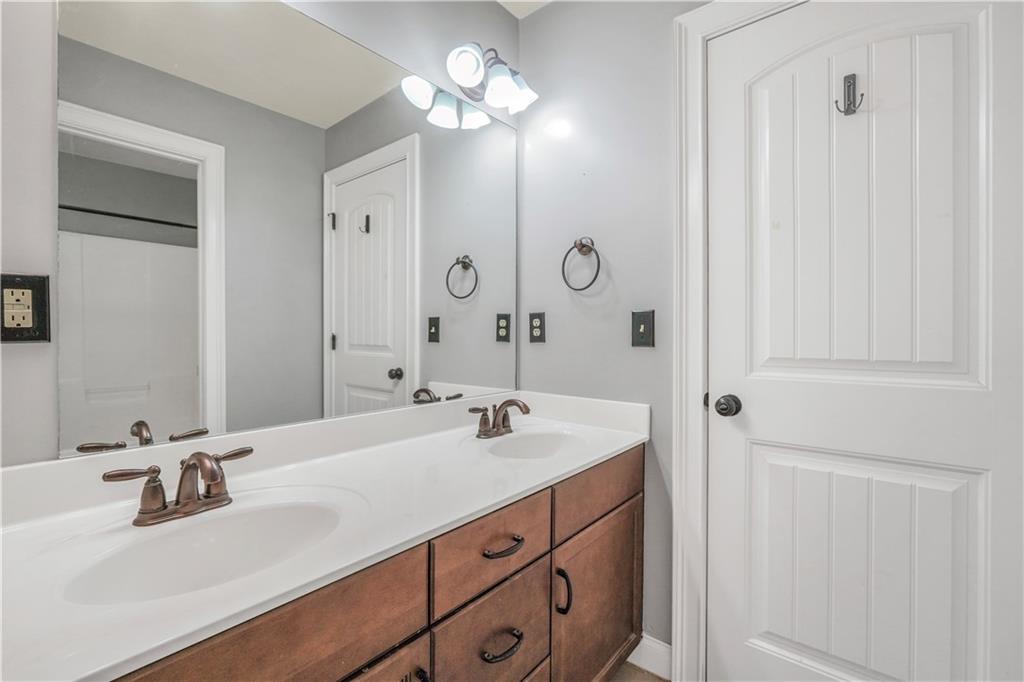 108 Caraway Road Locust Grove, GA 30248 - Photo 37 of 50 a bathroom with double vanity sink a vanity and mirror