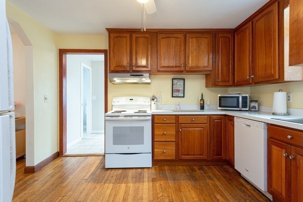 25 Porter Street Danvers, MA 01923 - Photo 17 of 42 a kitchen with granite countertop wooden floors and stainless steel appliances