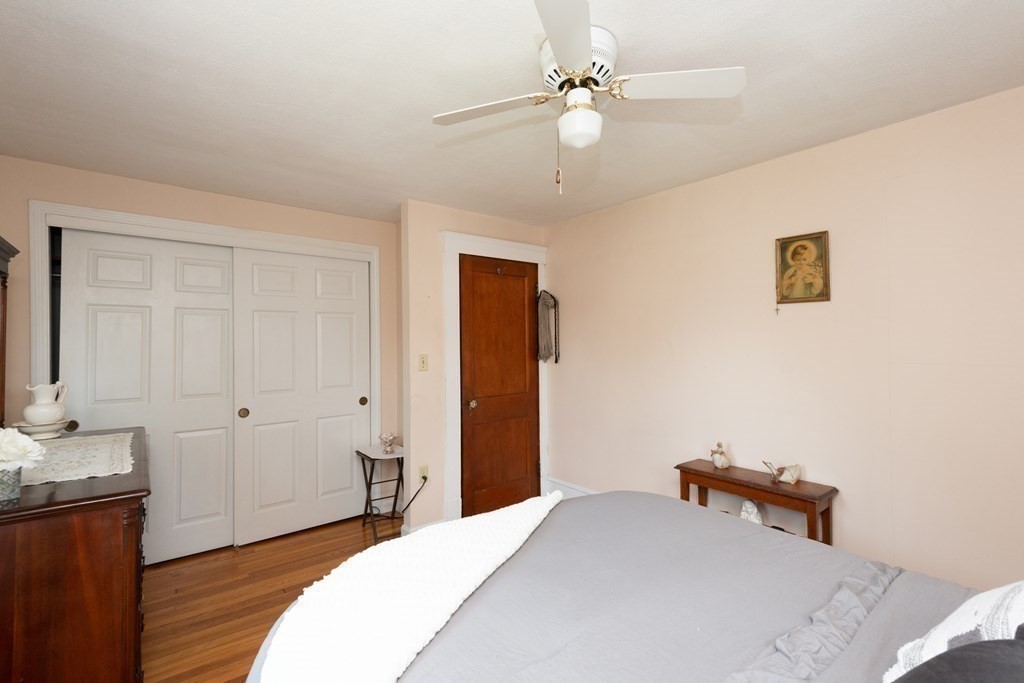 25 Porter Street Danvers, MA 01923 - Photo 32 of 42 a bedroom with a bed and a chandelier