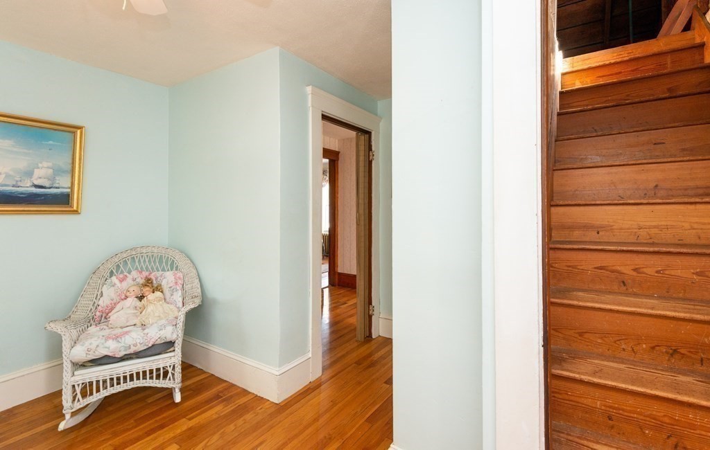 25 Porter Street Danvers, MA 01923 - Photo 39 of 42 a view of a hallway to a room with wooden floor and a dining room