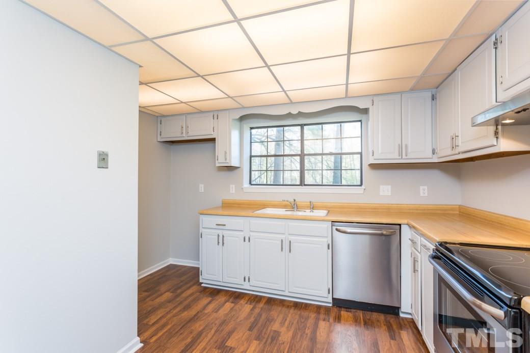 1306 Springlawn Court Raleigh, NC 27609 - Photo 3 of 19 a kitchen with granite countertop a sink cabinets and wooden floor