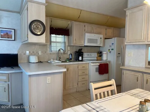 a kitchen with stainless steel appliances a stove a sink a cabinets and a clock on the wall