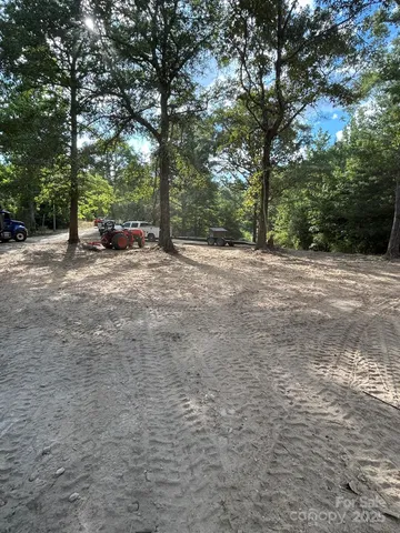 a view of dirt yard with a trees