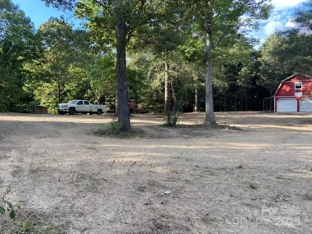 a view of a yard with large trees