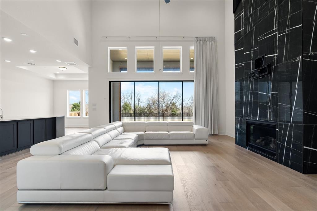 1161 Rochester Place Copper Canyon, TX 75077 - Photo 5 of 39 The living room is anchored by a striking fireplace, & a wall of glass doors opens wide for effortless indoor-outdoor entertaining.