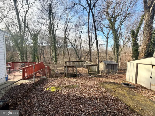a view of backyard with wooden fence and a bench