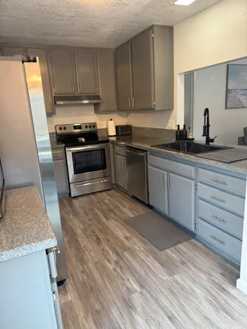 a kitchen with granite countertop wooden cabinets and white appliances