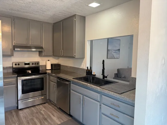 a kitchen with sink a microwave and cabinets