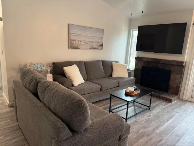 a living room with furniture a flat screen tv and a fireplace