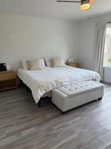 a bedroom with a bed and wooden floor