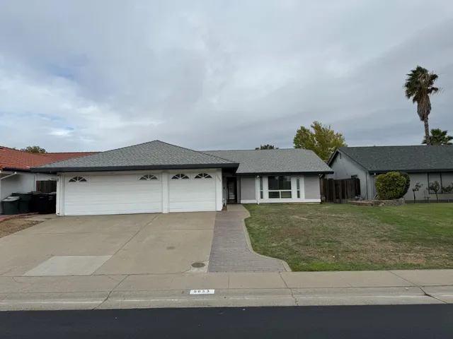 a front view of a house with a yard and garage