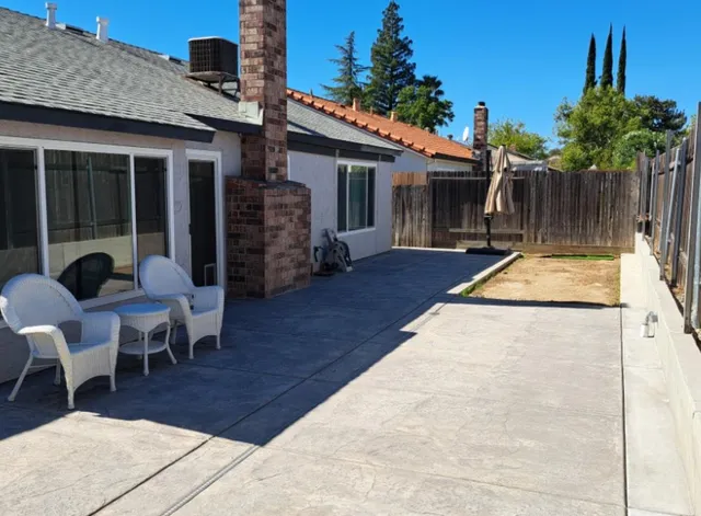 a view of a patio with table and chairs with wooden floor and fence