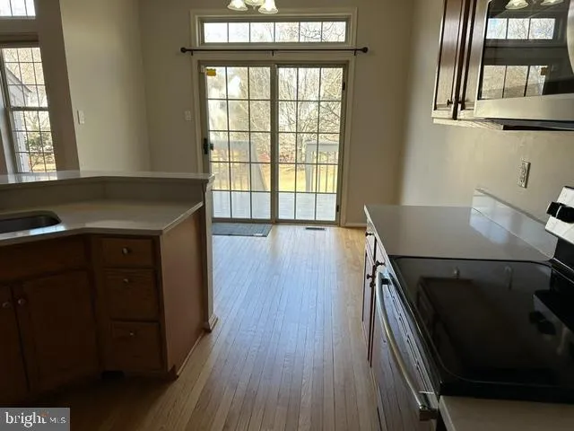 a kitchen with a wooden floor and a window