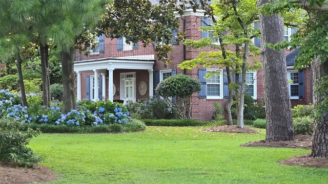 a front view of a house with a garden and plants