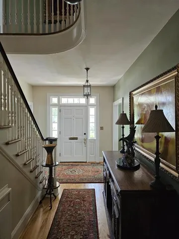 a front view of a dining room with furniture a chandelier and wooden floor