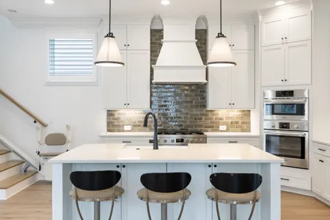 a kitchen with stainless steel appliances granite countertop a sink a stove a refrigerator and island